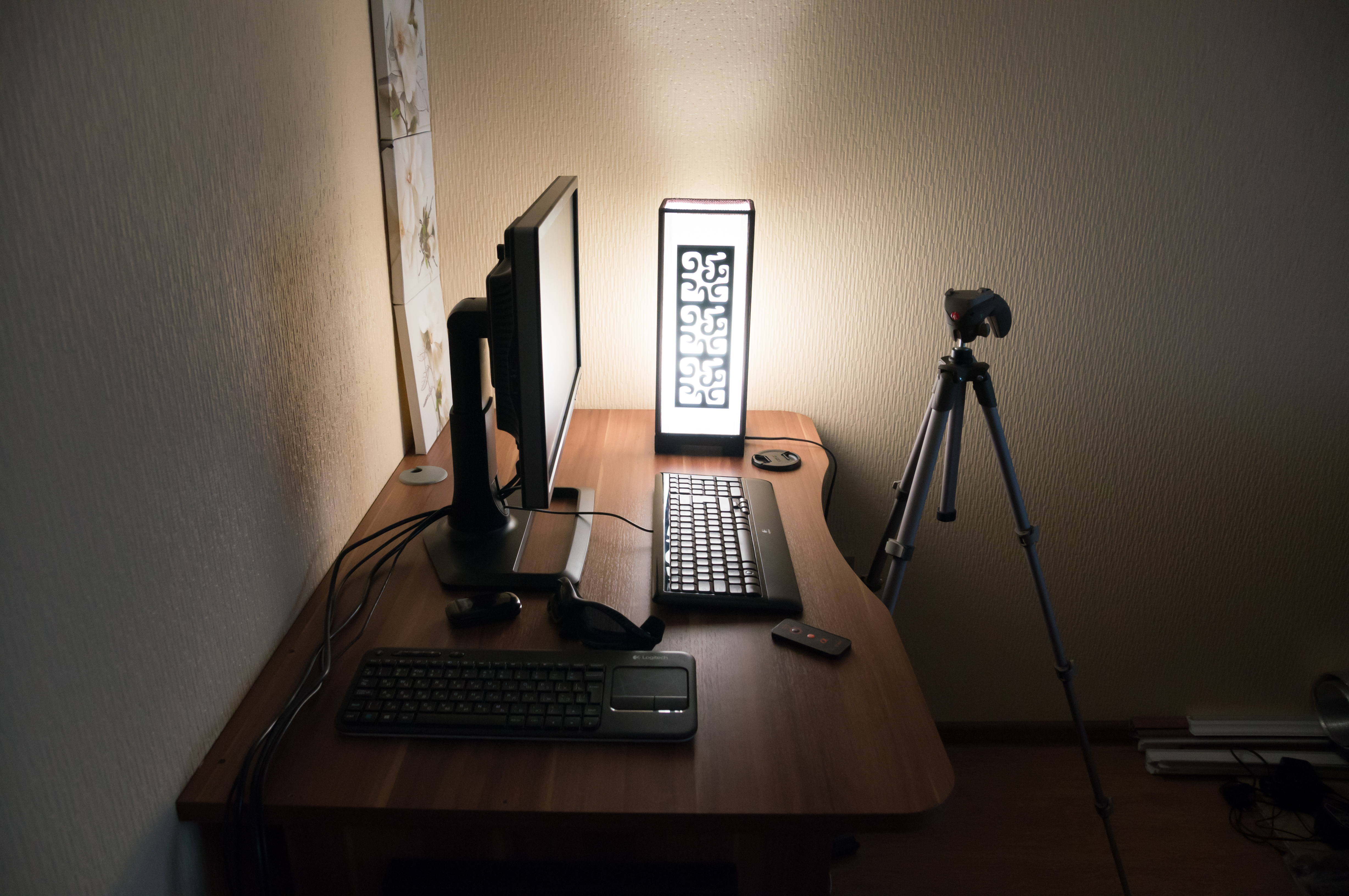 Bright home office desk with monitor, laptop, lamp, and notebook